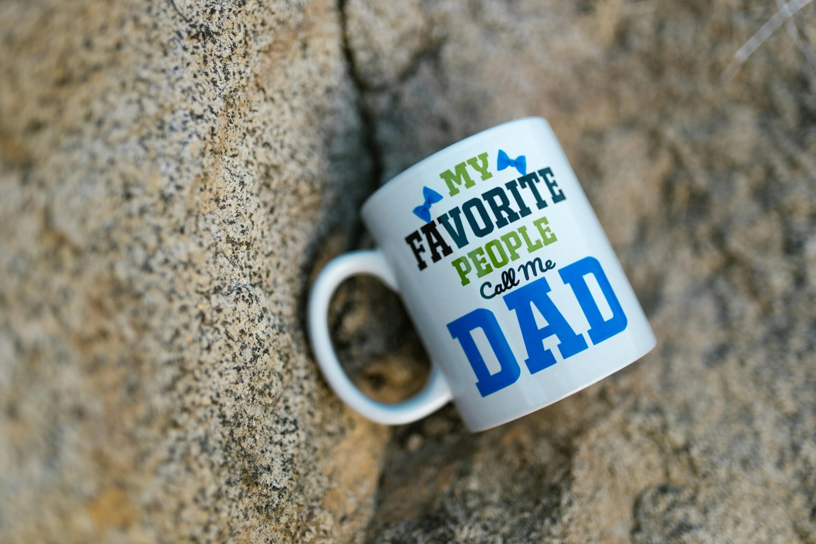Ceramic mug with 'My Favorite People Call Me Dad' design on a stone background.
